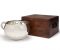 a photo of a silver chamber pot next to a brown wooden box