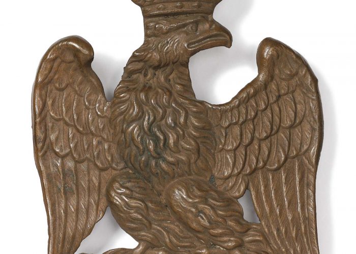 A photo of a metal eagle with crown decoration