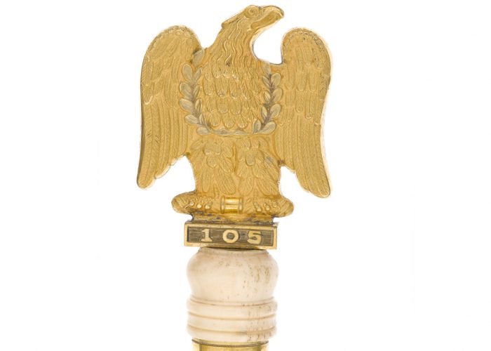 a photo of a gold eagle on top of a baton