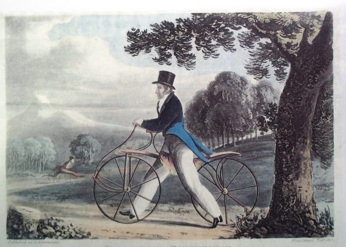 A painting of a well-dressed man in a top hat and tails, riding an early model of a bike in a park. A large tree can be seen in the foreground and towards the back you can see another man riding a similar bike.