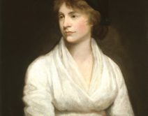 A portrait of a young woman dressed in a plain white dress and a dark black hat. She is gazing to the left of the frame with a still look on her face.