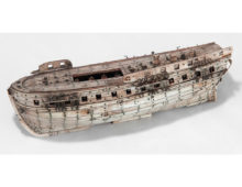 A small model of a boat made of bone.