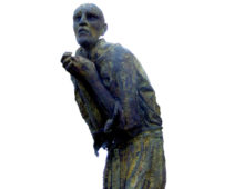 A photograph of a statue depicting a gaunt looking man, he is cowered over with his hands in a begging position and his eyes look sunken and scared.