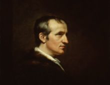 A portrait of a middle-aged man in profile. The man is dressed in dark clothes against a dark background so only his face and hair are really visible.