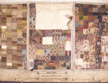 A photograph of the inside of a textile sample book. The worn parchment page is divided into three sections, each made up of little squares of different fabric patterns.