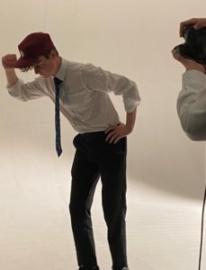 student in hat and tie posing for silhouette