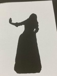 silhouette of figure in long dress holding out hand